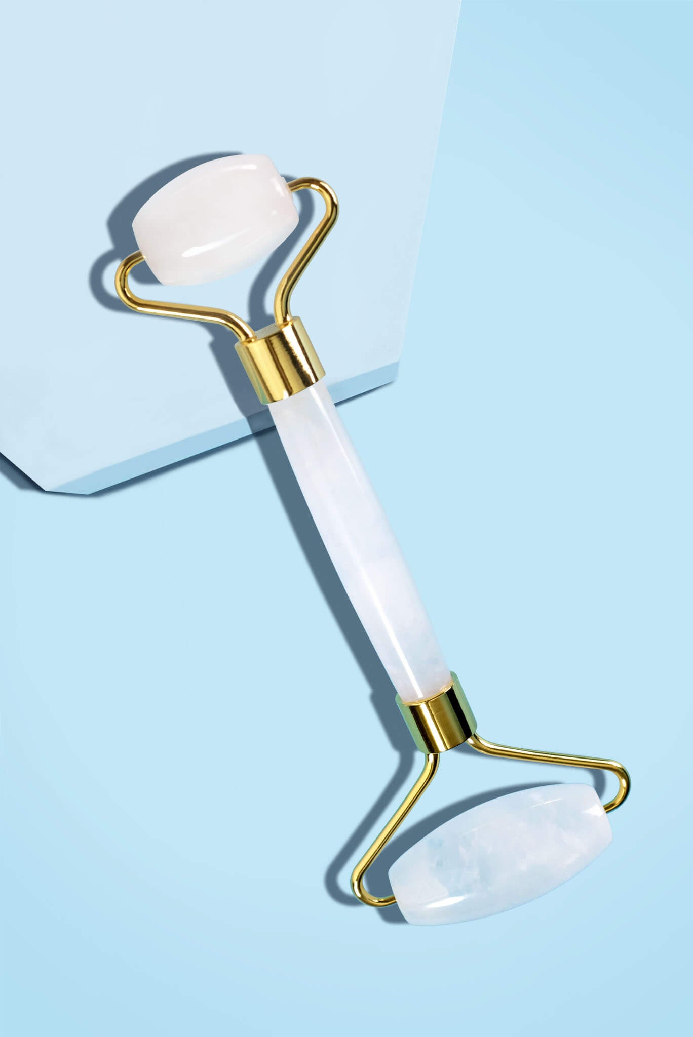 - ブルーのブロックに斜めに置かれたフェイスシャルローラー ミルキークォーツのスタイリング画像。
5.